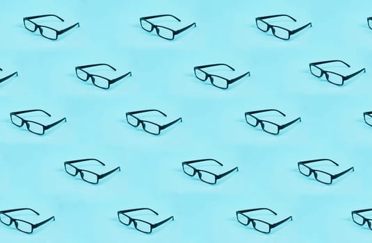 Many eyeglasses with a black frame on a blue background, copy space for text