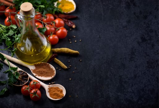 Various food ingredients and spices on rustic black background with copyspace.