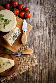 Different kinds of cheese on rustic wooden table