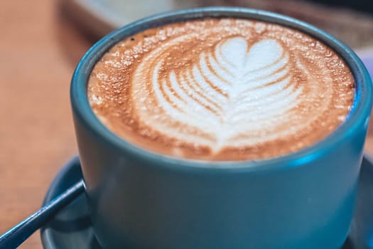 A cup of coffee latte top view with leaf shape foam