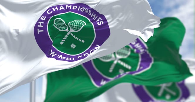 London, UK, April 2022: three flags with the The Championships Wimbledon logo waving in the wind. Wimbledon Championships is a major tennis tournament scheduled in late June each year