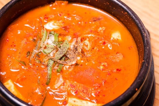 Kimchi soup in hot black iron pot, Korean traditional Kimchi Jjigae soup in bowl in the restaurant, Japanese hot pot food