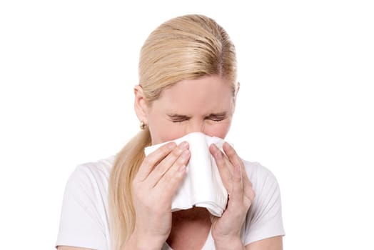 Unhealthy woman blowing  her nose into a tissue