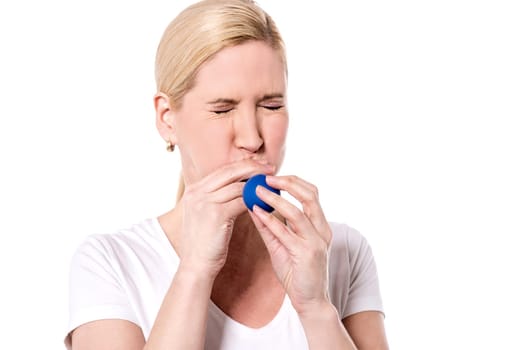 Young woman trying to inflate a balloon