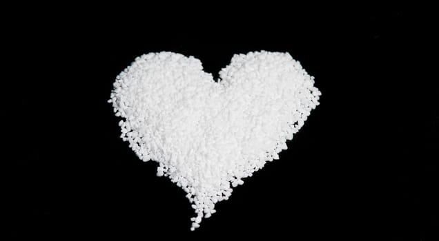 Nib Sugar in the Shape of an Heart with black background.