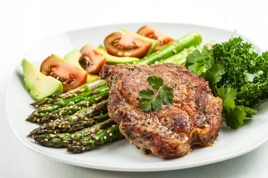 Glazed green asparagus with sesame seeds and grilled pork chop