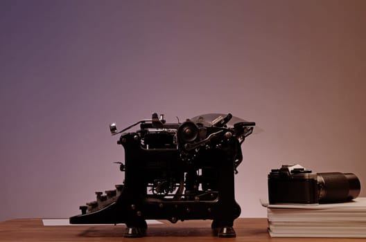 Old used typewriter with an old camera on an office table