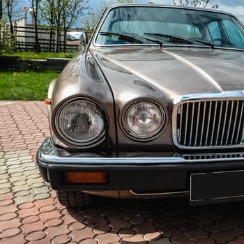 Old retro or vintage car or automobile front side with front lights or headlights and radiator grill