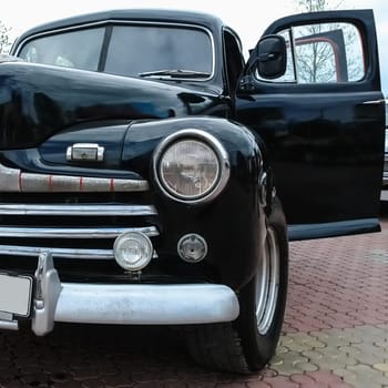 Old retro or vintage car or automobile front side with front lights or headlights and radiator grill