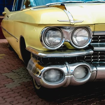 Old retro or vintage car or automobile front side with front lights or headlights and radiator grill