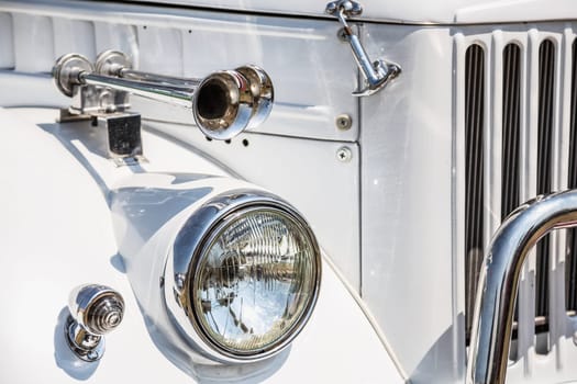 Old retro or vintage car or automobile front side with front lights or headlights and radiator grill