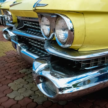 Old retro or vintage car or automobile front side with front lights or headlights and radiator grill