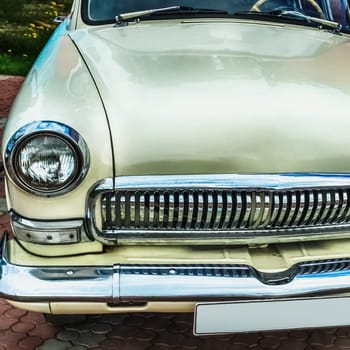 Old retro or vintage car or automobile front side with front lights or headlights and radiator grill