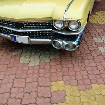 Old retro or vintage car or automobile front side with front lights or headlights and radiator grill
