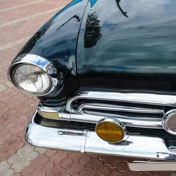 Old retro or vintage car or automobile front side with front lights or headlights and radiator grill