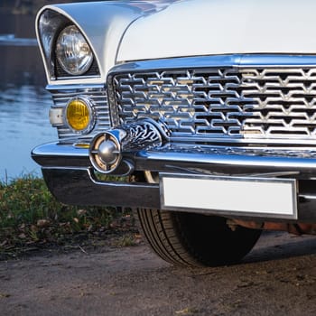 Old retro or vintage car or automobile front side with front lights or headlights and radiator grill