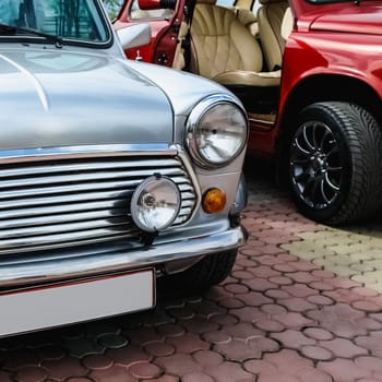 Old retro or vintage car or automobile front side with front lights or headlights and radiator grill