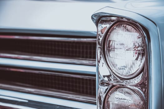 Front lights and radiator grill of an old vintage automobile. Processed by vintage or retro effect filter