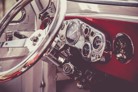 Interior of old retro vintage automobile or car with steering wheel and dashboard. Processed by vintage or retro effect filter
