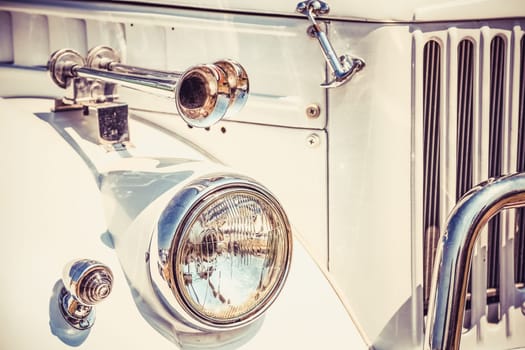 Old retro or vintage car or automobile front side with front lights or headlights and radiator grill. Processed by vintage or retro effect filter