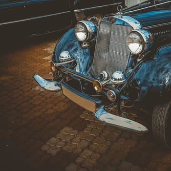 Old retro or vintage car or automobile front side with front lights or headlights and radiator grill. Processed by vintage or retro effect filter