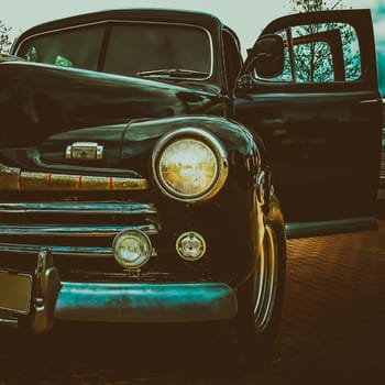 Old retro or vintage car or automobile front side with front lights or headlights and radiator grill. Processed by vintage or retro effect filter