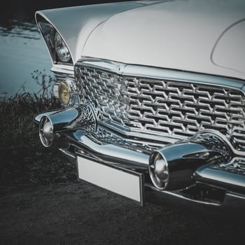 Old retro or vintage car or automobile front side with front lights or headlights and radiator grill. Processed by vintage or retro effect filter