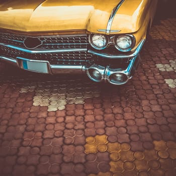Old retro or vintage car or automobile front side with front lights or headlights and radiator grill. Processed by vintage or retro effect filter