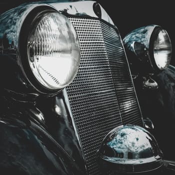 Old retro or vintage car or automobile front side with front lights or headlights and radiator grill. Processed by vintage or retro effect filter
