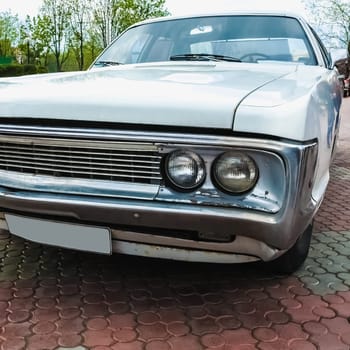 Old retro or vintage car or automobile front side with front lights or headlights and radiator grill