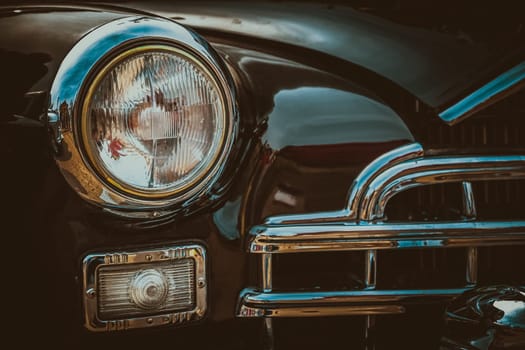 Front lights and radiator grill of an old vintage automobile. Processed by vintage or retro effect filter