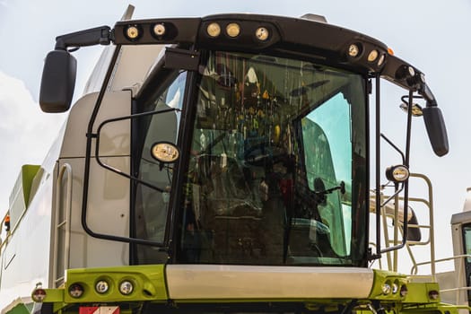 Cab of combine harvester closeup on sky background