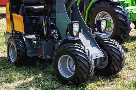 Small tractor in agriculture industry staying on grass ground