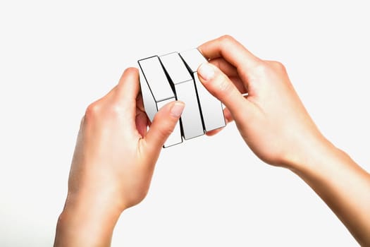 Hands holding or playing with white cube on white background