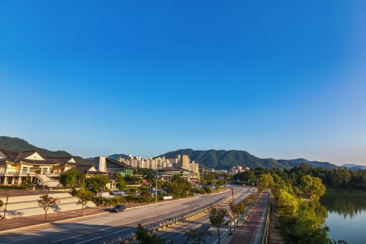 Chungju city cityscape in South Korea with old traditional and modern building architecture, central road, mountain and lake