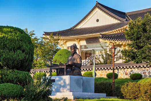 Sitting Confucius bronze statue on traditional architecture old building or temple background in South Korea