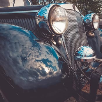 Old retro or vintage car or automobile front side with front lights or headlights and radiator grill. Processed by vintage or retro effect filter