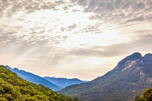 Mountains with green trees landscape and cloudy sky with sunbeams in South Korea