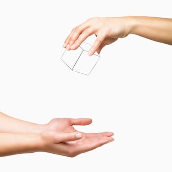 Hand holding and dropping white cube to other hand on white background