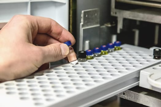 Laborant takes small bottle in research laboratory