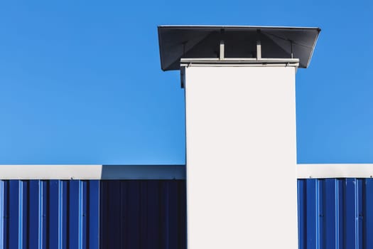 White chimney on building rooftop on blue sky background