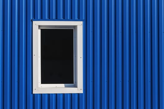 White window in blue color metal siding wall