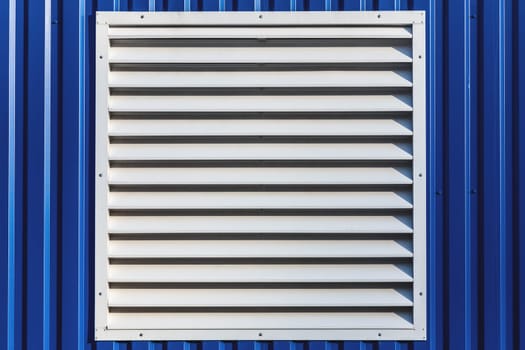 White window with jalousie in blue color metal siding wall