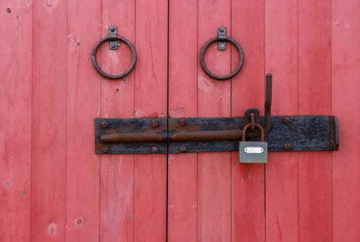 fragment of wooden doors with rusty gate and lock