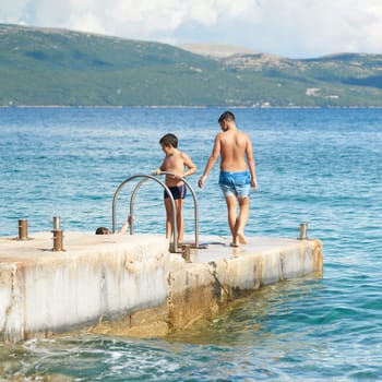 Children playing at a bathing place on the Adriatic Sea near the town of Krk in Croatia