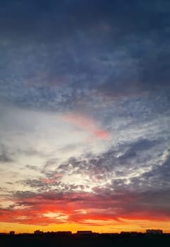 Dreamlike colorful sunset over the city horizon, vertical celestial  background