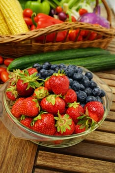 Fresh healthy strawberries and other fruits on a wooden table