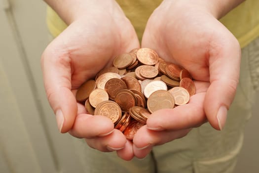 Many euro cent coins in woman hand