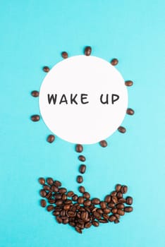 Flower made with coffee beans, the words wake up are standing on the blossom, good morning, having an espresso for breakfast, hot drink