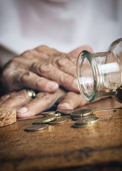 Elderly retired woman and her savings in a jar